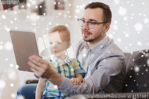 Image of father and son with tablet pc playing at home