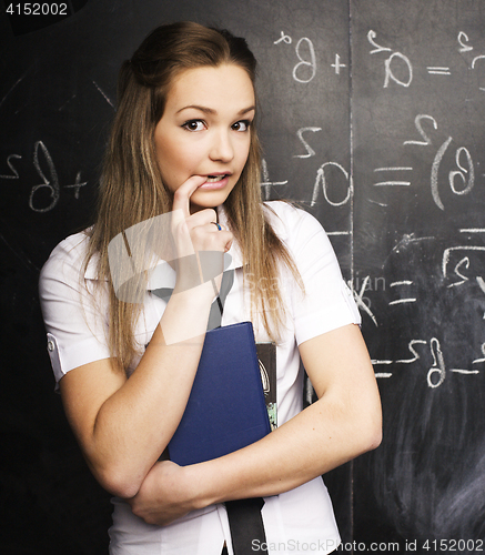 Image of portrait of happy cute student with book in classroom at blackboard, lifestyle education people concept