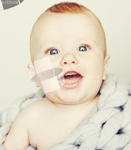 Image of little cute red head baby in scarf all over him close up isolate