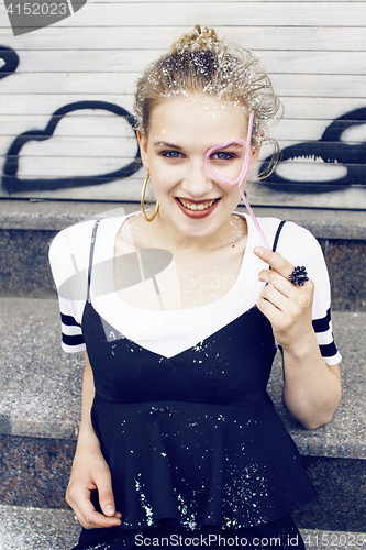 Image of young pretty party girl smiling covered with glitter tinsel, fas