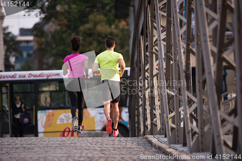 Image of multiethnic couple jogging in the city