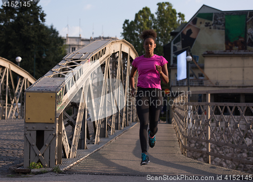 Image of african american woman running across the bridge