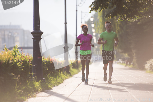 Image of young multiethnic couple jogging in the city
