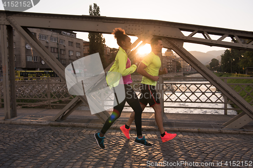 Image of young multiethnic couple jogging in the city