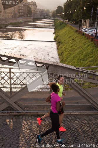 Image of young multiethnic couple jogging in the city