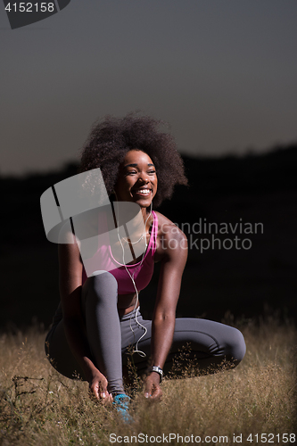 Image of black woman runner tightening shoe lace