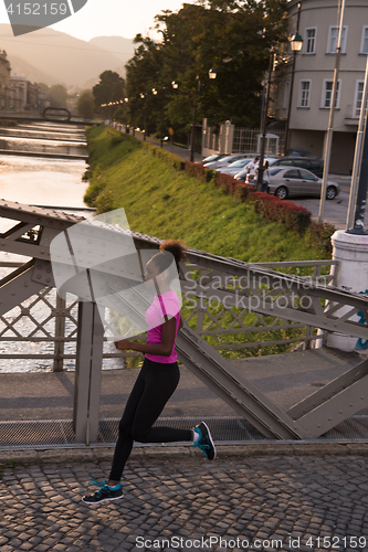 Image of african american woman running across the bridge