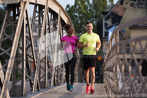 Image of multiethnic couple jogging in the city