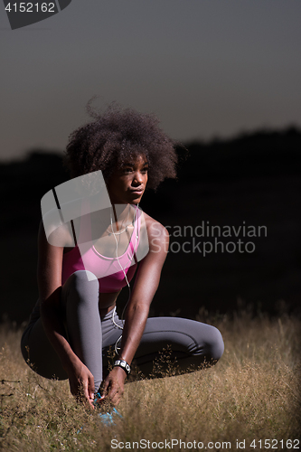 Image of black woman runner tightening shoe lace