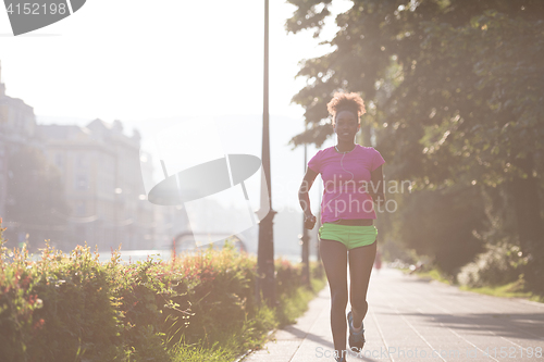 Image of african american woman jogging in the city