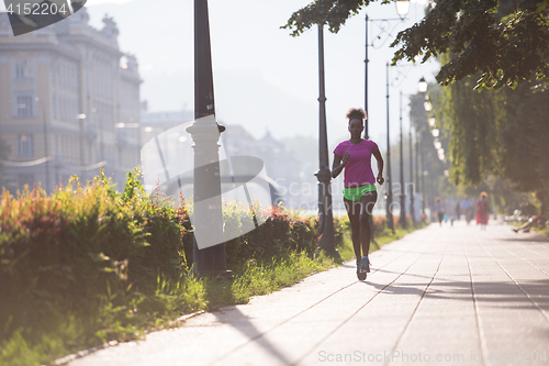 Image of african american woman jogging in the city