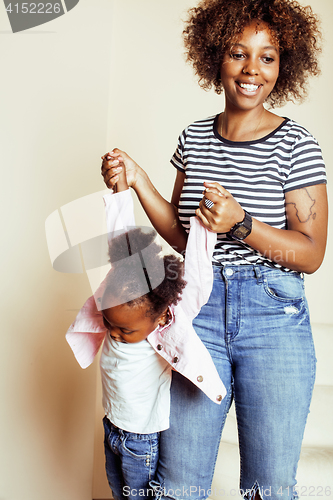 Image of adorable sweet young afro-american mother with cute little daughter, hanging at home, having fun playing smiling, lifestyle people concept, happy smiling modern family