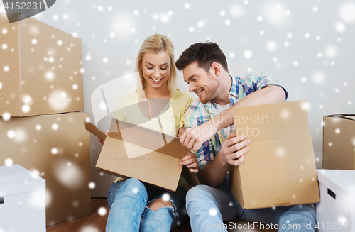 Image of smiling couple with big boxes moving to new home