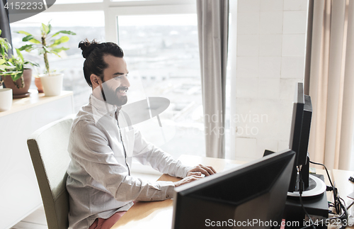 Image of happy creative male office worker with computer