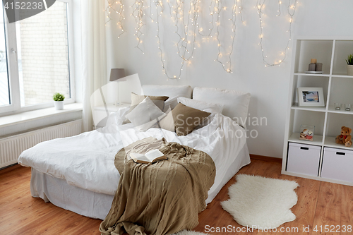 Image of bedroom with bed and christmas garland at home