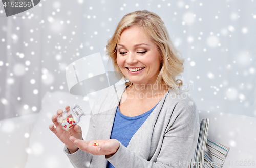 Image of happy middle aged woman with medicine at home