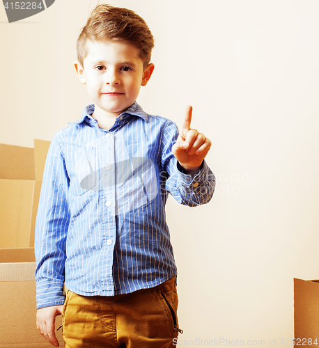 Image of little cute boy in empty room, remoove to new house. home alone,