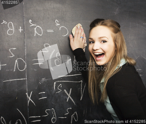 Image of portrait of happy cute student with book in classroom at blackboard, lifestyle education people concept