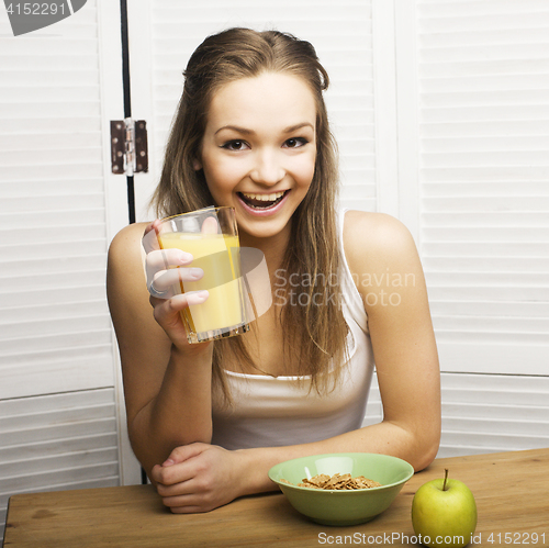 Image of portrait of happy cute girl with breakfast, green apple and orange juice