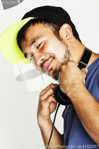 Image of young asian man in hat and headphones listening music on white b