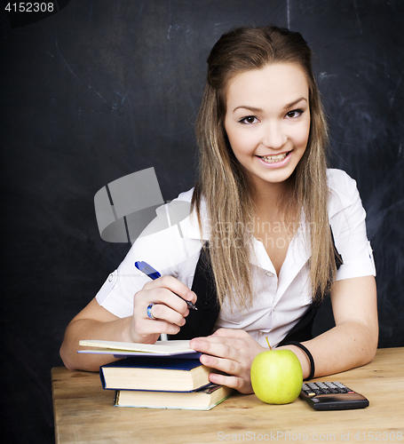 Image of portrait of happy cute student with book in classroom