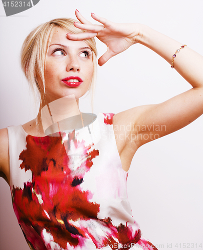 Image of young pretty blonde girl presenting something at white copy space, emotional posing, lifestyle people concept