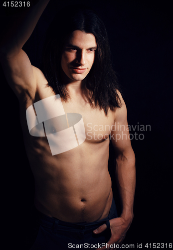 Image of handsome young man with long hair naked torso on black background