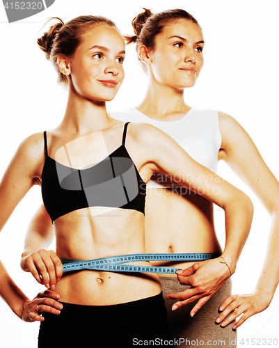 Image of two sport girls measuring themselves isolated on white