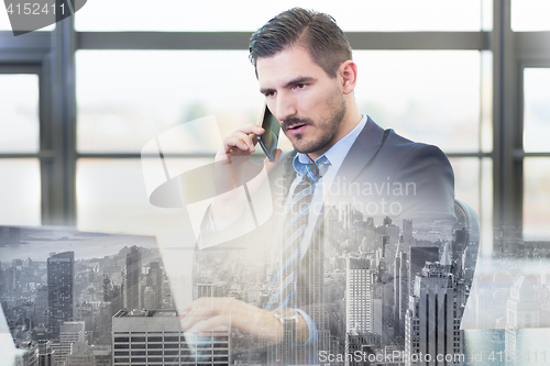 Image of Businessman in office working on laptop computer.