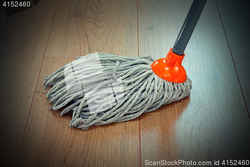 Image of detail of wooden floor cleaning with mop