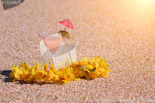 Image of Tropical Drink and Lei on Beach Shoreline