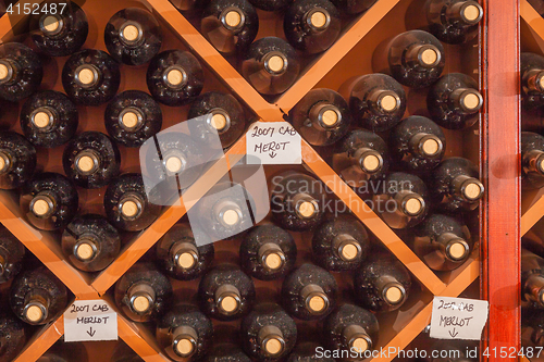 Image of Several Varietal Wine Bottles Age Inside Cellar