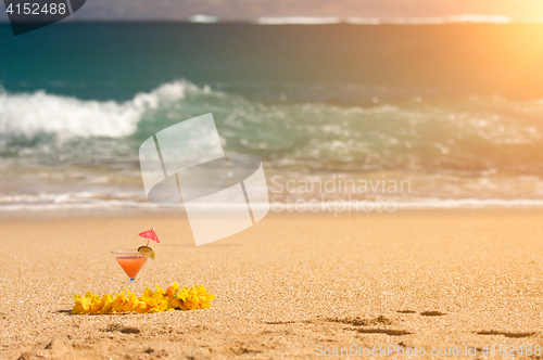 Image of Tropical Drink and Lei on Beach Shoreline