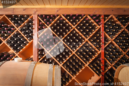 Image of Wine Barrels and Bottles Age Inside Cellar