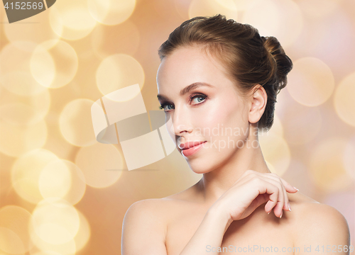 Image of beautiful young woman face over holidays lights