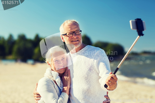 Image of happy senior couple hugging on summer beach