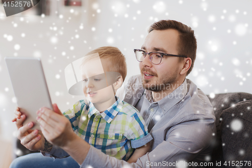 Image of father and son with tablet pc playing at home