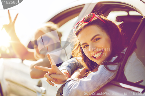 Image of happy teenage girls or women in car at seaside