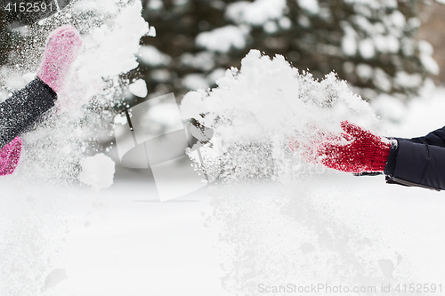 Image of happy friends playing with snow in winter