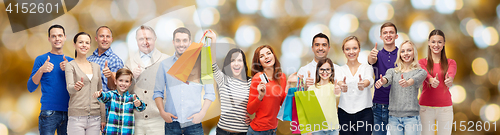 Image of happy people with shopping bags showing thumbs up