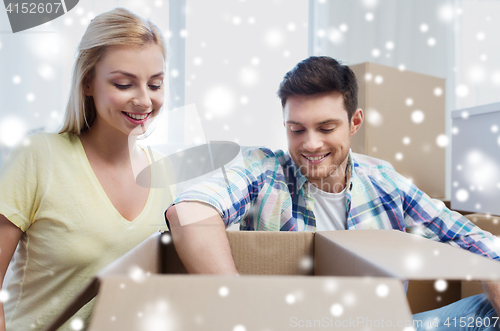 Image of smiling couple with big boxes moving to new home