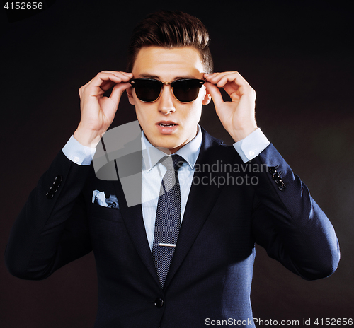 Image of young pretty business man standing on black background, modern h