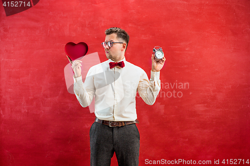 Image of Young funny man with abstract heart and clock