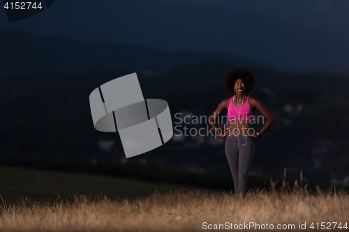 Image of Young African american woman jogging in nature