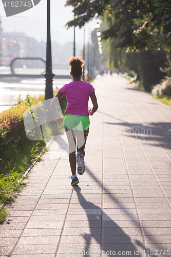 Image of african american woman jogging in the city