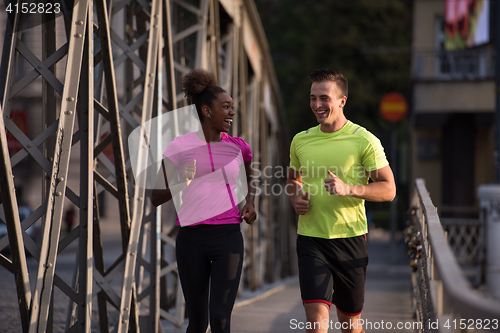 Image of multiethnic couple jogging in the city