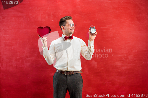 Image of Young funny man with abstract heart and clock