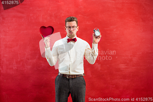 Image of Young funny man with abstract heart and clock