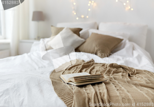 Image of bedroom with bed and christmas garland at home