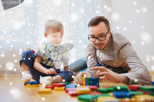 Image of father and son playing with toy blocks at home